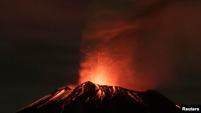 Volcán de Fuego erupting against a dark sky with glowing lava and ash plume in Guatemala