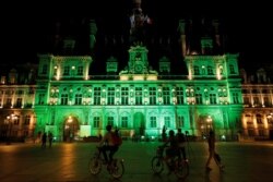 FILE - Green lights are projected onto the facade of the Hotel de Ville in Paris, France, after US President Donald Trump announced his decision that the United States will withdraw from the Paris Climate Agreement.