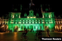 FILE - Green lights are projected onto the facade of the Hotel de Ville in Paris, France, after US President Donald Trump announced his decision that the United States will withdraw from the Paris Climate Agreement.