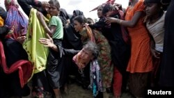 A Rohingya refugee reacts as people scuffle while waiting to receive aid in Cox's Bazar, Bangladesh, Sept. 26, 2017. 