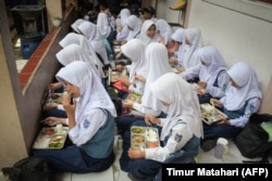 Siswa menyantap makan siang pada hari pertama program makan gratis di SMP Negeri 12 Cimahi, Jawa Barat, 6 Januari 2025. (Foto: Timur Matahari/AFP)