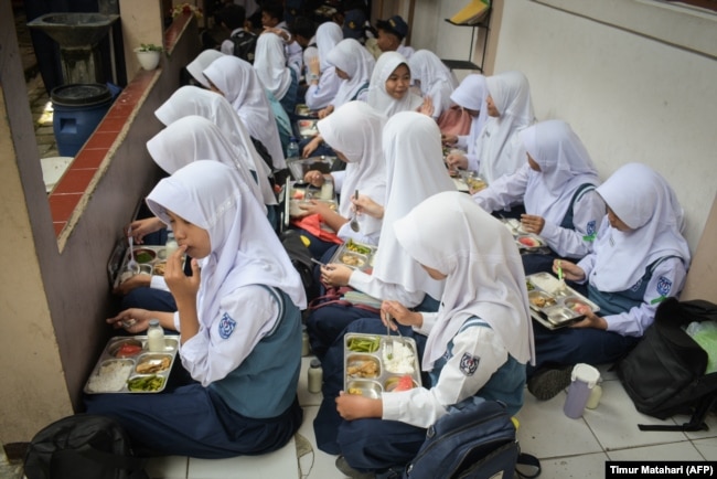 Siswa menyantap makan siang pada hari pertama program makan gratis di SMP Negeri 12 Cimahi, Jawa Barat, 6 Januari 2025. (Foto: Timur Matahari/AFP)