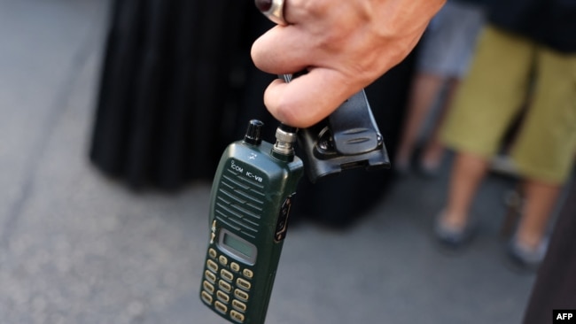 A man holds a walkie-talkie device after he removed the battery, in Beirut's southern suburbs on Sept. 18, 2024.