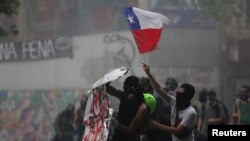 Demonstrators wave a Chile flag during a protest against Chile's government in Santiago, Chile, Nov. 11, 2019. 