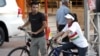 FILE - A Kurdish man and a woman wearing a T-shirt with the Kurdish flag printed on it ride their bikes in the northern city of Sulaimaniyah in the autonomous Kurdish region, July 21, 2009. 