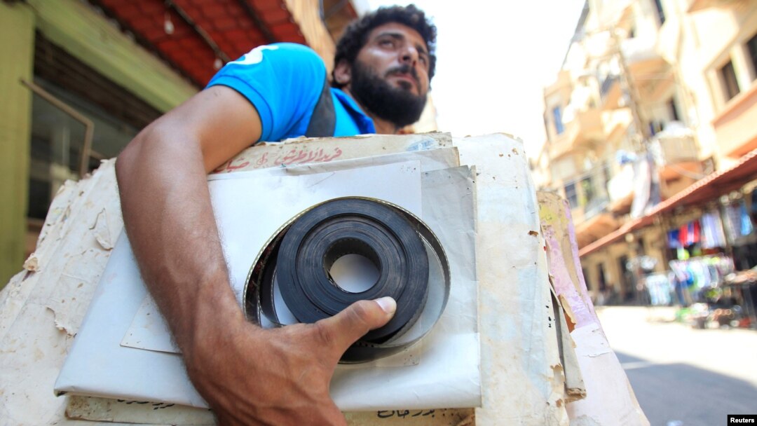 Qassem Istanbouli holds a film negative, in Tripoli, Lebanon, July 5, 2017. Istanbouli is restoring old cinemas into cultural centers.