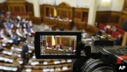 FILE - The rostrum of Ukraine's parliament is seen through a reporter's camera monitor in Kyiv, Sept. 17, 2015. As part of an IMF loan, top officials, including lawmakers, recently declared millions in cash and luxury cars but activists say the agency probing their wealth lacks funding.