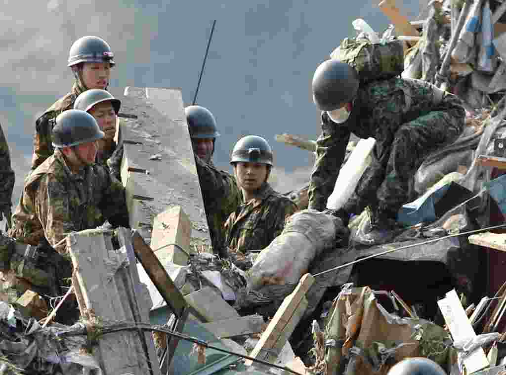 Recatistas trabajan para recuperar los cuerpos de las víctimas tras el terremoto de 8,9 grados y el consiguiente tsunami en el norte de Japón.