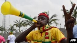 Un supporter du Mali gesticule et souffle une corne de vuvuzela à l'arrivée de l'équipe du Mali à l'aéroport de Malabo, avant le tournoi de football de la Coupe d'Afrique des nations 2015, le 16 janvier 2015,.