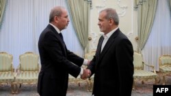 A handout picture released by the Iranian presidential office shows Iranian President Masoud Pezeshkian, right, welcoming Jordan's foreign minister Ayman Safadi ahead of their meeting in Tehran on Aug. 4, 2024. (Photo by Iranian Presidency / AFP)