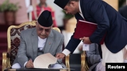 Newly appointed Prime Minister KP Sharma Oli signs a document after taking the oath of office at the presidential building "Shital Niwas" in Kathmandu, Nepal, July 15, 2024.