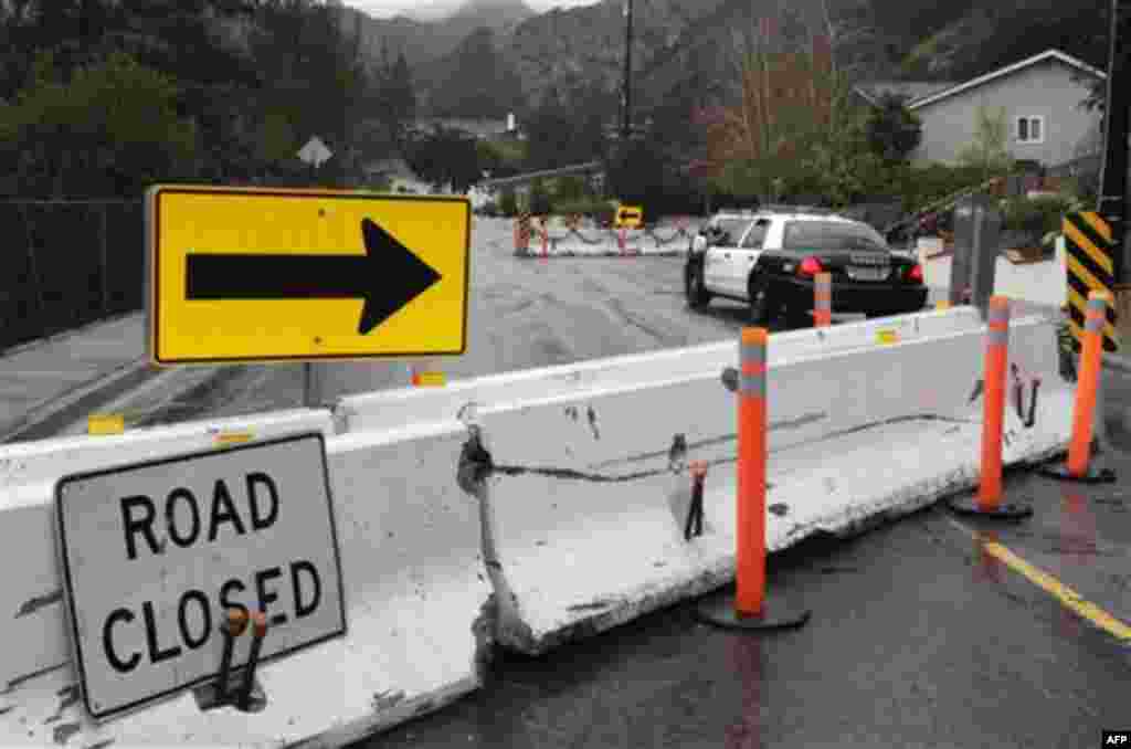 K-rails are set up at a road closure in La Canada Flintridge, Calif., Wednesday, Dec. 22, 2010. A storm that flooded Southern California and forced dozens of evacuations appears to be easing, but authorities say the threat of mudslides will continue for w