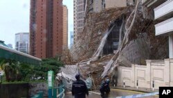 Para petugas memeriksa lokasi robohnya perancah saat cuaca buruk di Hong Kong, Jumat, 8 Oktober 2021. (TVB via AP Video)