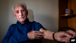 FILE -— In this January 10, 2020 photo Auschwitz survivor Leon Weintraub, 94, shows his arm where he has no identification number as he poses for a portrait in his apartment in Stockholm, Sweden. 