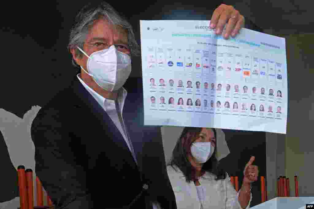 El candidato presidencial ecuatoriano Guillermo Lasso, acompa&#241;ado de su esposa Mar&#237;a de Lourdes Alcivar, muestra su voto en la Unidad Educativa Ileana Espine, durante las elecciones generales, en Cuenca, Ecuador, el 7 de febrero de 2021.
