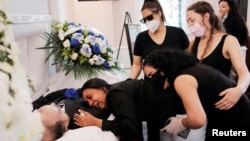 Maria Ortiz embraces the body of her partner Jose Holguin, 50, who died of complications related to COVID-19, New York City, May 16, 2020.