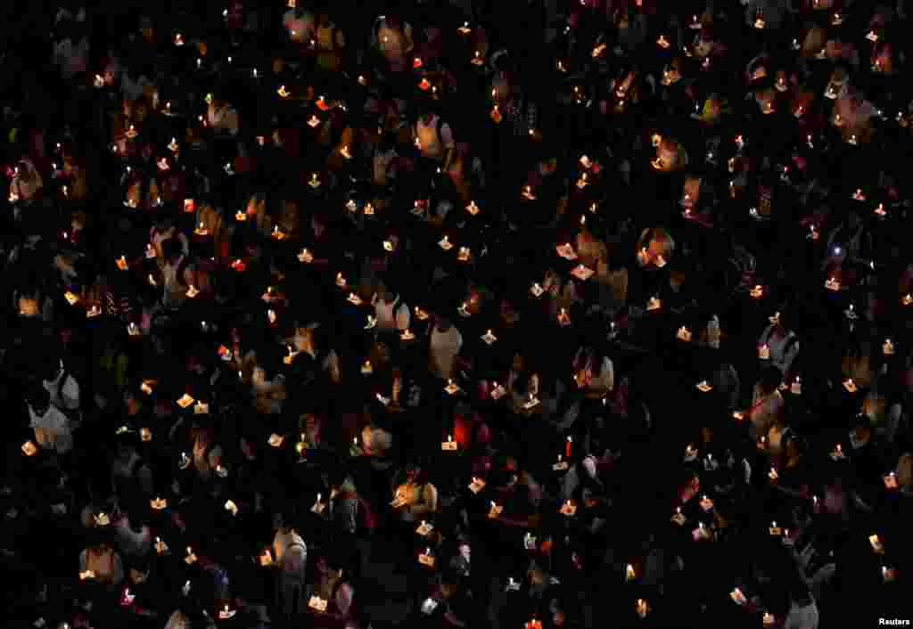 College students in Kolkata, India, hold candles during a vigil to pay tribute to Central Reserve Police Force (CRPF) personnel who were killed after a suicide bomber rammed a car into the bus carrying them in south Kashmir last week.