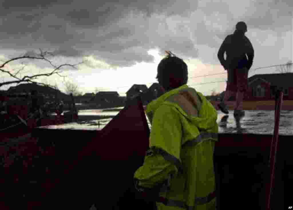 A worker emerges from a tornado shelter to see if there is any new damage to the area already damaged by an earlier tornado on Friday, March. 2, 2012, in Athens, Ala. Powerful storms stretching from the U.S. Gulf Coast to the Great Lakes in the north wrec
