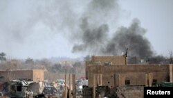 FILE - Islamic State members walk in the last besieged neighborhood in the village of Baghouz, Deir Al Zor province, Syria, March 10, 2019. 