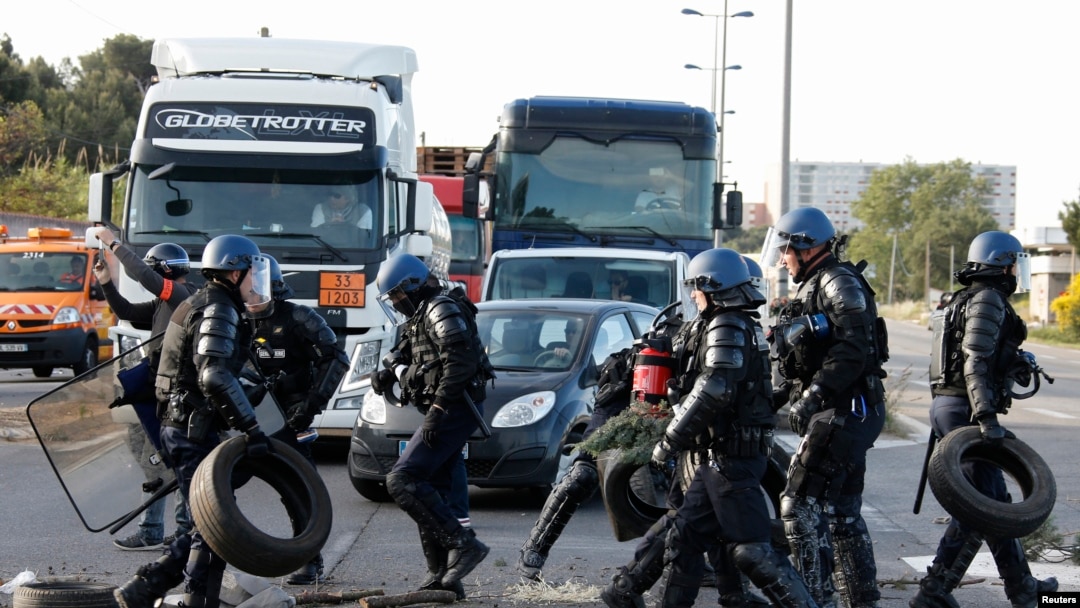 French gendarmes remove branches, wood pallettes and tyres after striking workers blocked roads near the oil refinery at Fos-sur-Mer, near Marseille, France, May 24, 2016 with France's hardline CGT and FO unions toughening their stance against labor market reforms.
