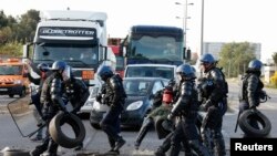 French gendarmes remove branches, wood pallettes and tyres after striking workers blocked roads near the oil refinery at Fos-sur-Mer, near Marseille, France, May 24, 2016 with France's hardline CGT and FO unions toughening their stance against labor market reforms.