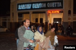 Passengers who were rescued from a train after it was attacked by separatist militants, walk with their belongings at the Railway Station in Quetta, Balochistan, Pakistan, March 12, 2025.