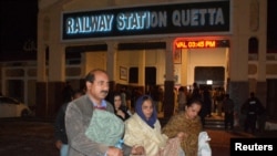 Passengers who were rescued from a train after it was attacked by separatist militants, walk with their belongings at the Railway Station in Quetta, Balochistan, Pakistan, March 12, 2025.