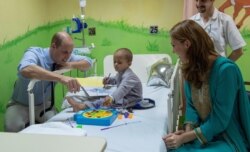 FILE - Britain's Prince William and Kate, Duchess of Cambridge, visit a 5-year-old Muhammed Sameer at the Shaukat Khanum Memorial Cancer Hospital in Lahore, Pakistan, Oct. 17, 2019.