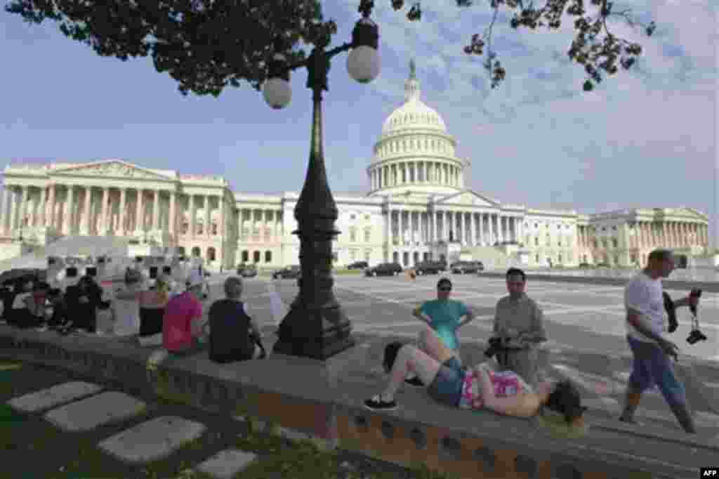 Tourists take a break in the shade on Capitol Hill in Washington, Thursday, July 28, 2011, as House Republicans pressed ahead with a vote on a newly modified plan to stave off an unprecedented government default next week. (AP Photo/J. Scott Applewhite)