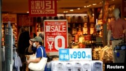 FILE - A shopper wearing a protective face mask is seen at a shop selling office wear, amid the coronavirus disease (COVID-19) outbreak in Tokyo, Japan, July 27, 2020.