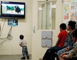 FILE - A detained immigrant child watches a cartoon with other young detained immigrants at a U.S Customs and Border patrol immigration detainee processing facility in Tucson, Arizona, June 28, 2018.