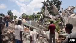 FILE - People search through the rubble of what used to be the Manguier Hotel after the earthquake hit on August 14, 2021 in Les Cayes, southwest Haiti.