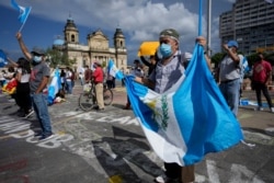 Manifestantes ondean banderas durante un mitin para pedir la renuncia del presidente guatemalteco Alejandro Giammattei, alegando que su gobierno ha manejado mal la pandemia y frustrado los esfuerzos para obtener vacunas, el 17 de julio de 2021.