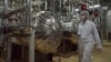 FILE - An Iranian security official in protective clothing walks through part of the Uranium Conversion Facility just outside the Iranian city of Isfahan.