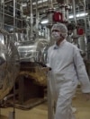 FILE - An Iranian security official in protective clothing walks through part of the Uranium Conversion Facility just outside the Iranian city of Isfahan.