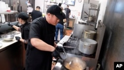 FILE - Tito Thepkaysone cooks pad Thai at "Love & Thai" restaurant in Fresno, California, Dec. 20, 2023. The Thai restaurant was wrongfully accused of abusing a dog to turn it into meat, a false claim rooted in a racist stereotype.