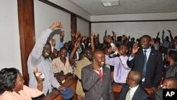 Uganda's top opposition leader Kizza Besigye, second left (A4C participant), waves to supporters inside the court in Kampala, Uganda after he was freed on bail, March 28, 2012. 