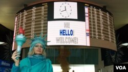 Lindley Hanlon, profesor film di CUNY, menyambut para pengungsi sepanjang Senin sore (6/2) di bandar udara internasional JFK, New York. (VOA/Ramon Taylor)