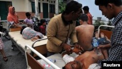 Injured residents receive treatment outside the local clinic after a strong earthquake hit in Bener Meriah district in Central Aceh, Indonesia, July 2, 2013. 