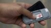 A mobile phone user in Juba, South Sudan checks his SIM card. Thursday, February 28, was the deadline to register SIM cards with the government. (VOA)