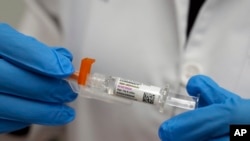 A pharmacist holds a COVID-19 vaccine at a pharmacy in New York, Sept. 24, 2024. 