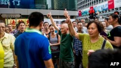 People react to pro-democracy protests in Hong Kong's Mongkok district, Oct. 11, 2014. 