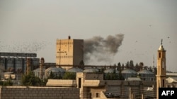 Smoke billows following Turkish bombardment on Syria's northeastern town of Ras al Ain in the Hasakeh province along the Turkish border, Oct. 9, 2019.