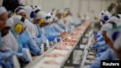 FILE - Employees work at the Brazilian meatpacker JBS SA in the city of Lapa, Parana state, Brazil, March 21, 2017.