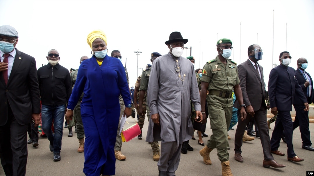 Mantan Presiden Nigeria Goodluck Jonathan (tengah) berjalan di Bandara Internasional di Bamako setelah kedatangannya pada 22 Agustus 2020, sebagai bagian dari upaya internasional untuk memulihkan ketertiban di Mali setelah kudeta militer. (Foto: AFP)