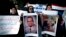 Muslim Brotherhood supporter carries a banner, center, in Arabic that reads, "freedom to doctor Mohammed Abdel Monem, arrested in the United Arab Emirates," during an ongoing protest in front of the United Arab Emirates embassy, unseen, in Cairo, Egypt, J