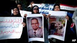 Muslim Brotherhood supporter carries a banner, center, in Arabic that reads, "freedom to doctor Mohammed Abdel Monem, arrested in the United Arab Emirates," during an ongoing protest in front of the United Arab Emirates embassy, unseen, in Cairo, Egypt, J