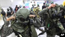 South Korean army soldiers put on gas masks during South Korea-U.S. joint military exercise, "Ulchi Focus Lens," at a subway station in Seoul, South Korea, Aug. 19, 2013.