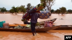 Seorang warga berusaha menyelamatkan barang-barangnya dari banjir di Niamey, Niger (foto: dok). 