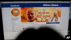 FILE - A woman checks the Facebook page of India's ruling Bharatiya Janata Party, in New Delhi, March 26, 2019.